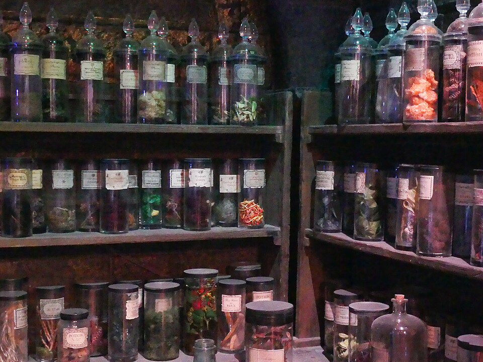 Shelves of glass bottles and jars in a potions classroom.